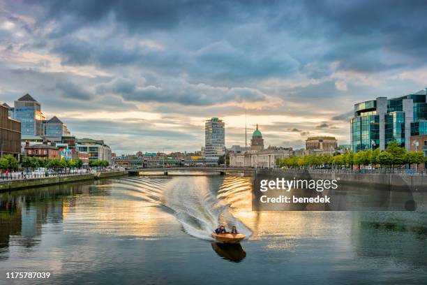 motorboat speeding on river liffey dublin ireland - dublin imagens e fotografias de stock