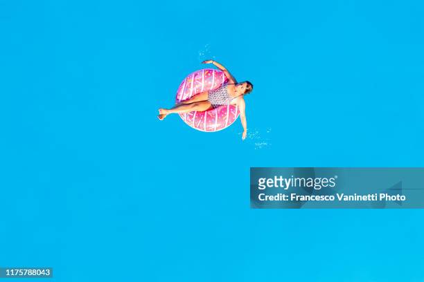 woman relaxing on an inflatable ring on the sea, lefkada, greece. - luftmatratze von oben stock-fotos und bilder