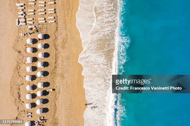 beach umbrellas on milos beach, lefkada, greece. - levkas stock pictures, royalty-free photos & images