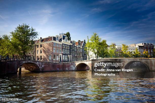 amsterdam canal viewed from the water - amsterdam canals stockfoto's en -beelden