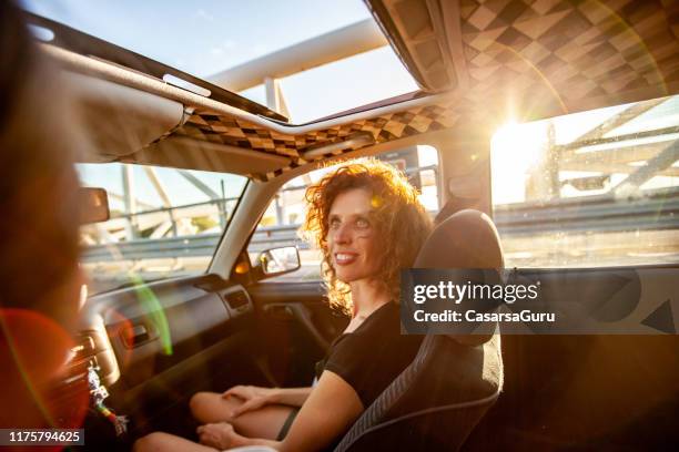 young woman portrait on the road trip from inside the car - sunroof stock pictures, royalty-free photos & images