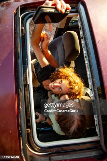 gelukkig reizend paar op een reis die een pauze neemt om een selfie te maken - car sunroof stockfoto's en -beelden