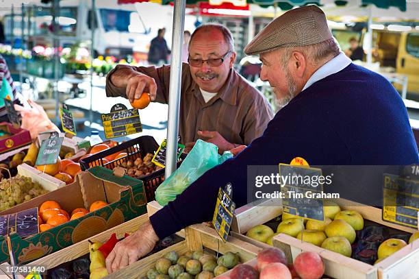 Frenchmen working on fruit staff at food market at Esplanade des Quais in La Reole, Bordeaux region, France