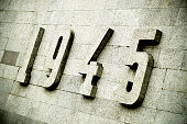 Relief panel with numerals. 1945 relief panel on a grey marble wall. World War II monument.