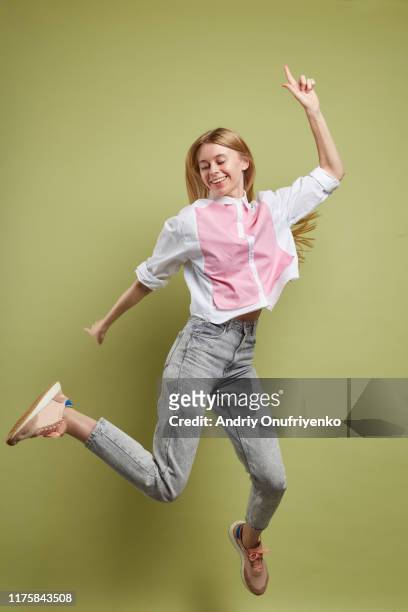 young adult female jumping for joy - frau springt hüpft stock-fotos und bilder