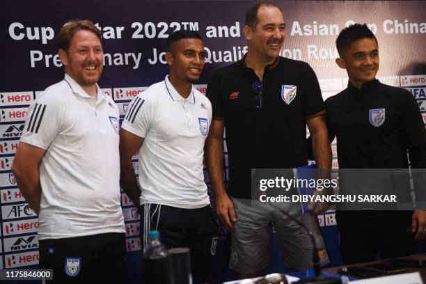 Bangladesh's football coach Jamie Day and Bangladeshi football captain Jamal Bhuyan pose for photographs next to India's coach Igor Stimac and Indian...