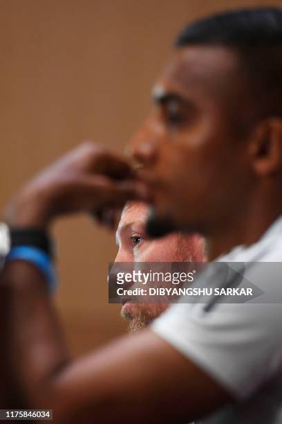 Bangladesh's football coach Jamie Day listens to a question next to Bangladeshi captain Jamal Bhuyan and gestures during a press conference on the...