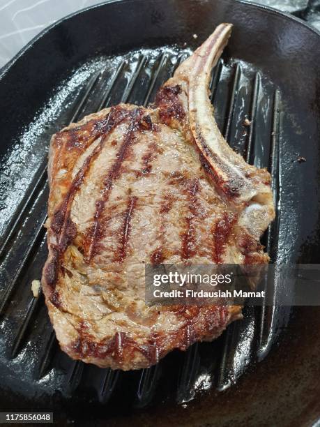 cooking rib eye, ribeye beef steak in grill pan - rib eye steak stockfoto's en -beelden