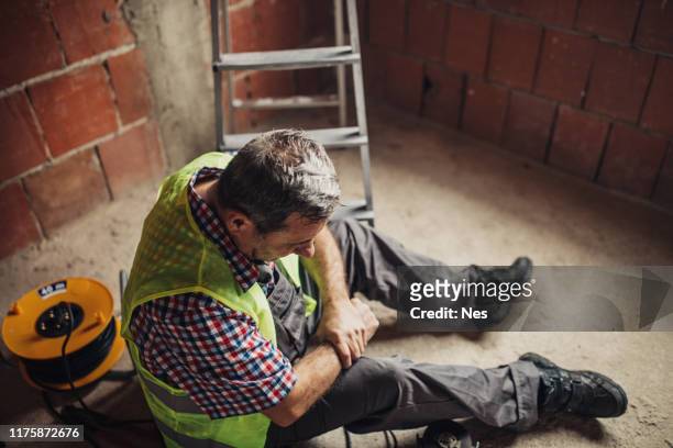 körperverletzung bei der arbeit eines bauarbeiters - arbeitsunfall stock-fotos und bilder