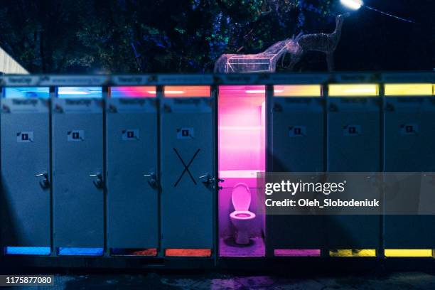 bio toilet with opened door on music festival with pink light in - film festival stock pictures, royalty-free photos & images