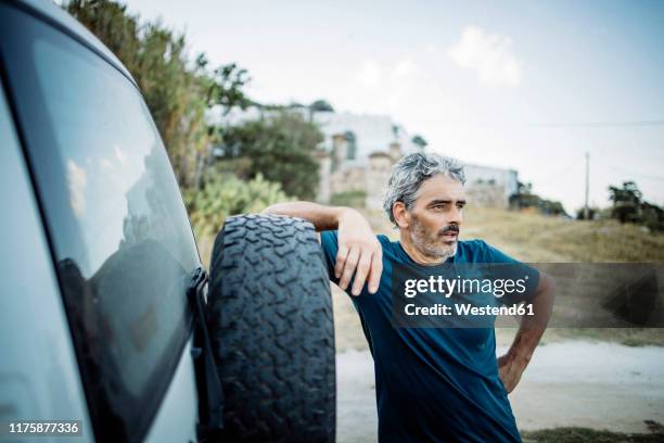 mature man standing at his off-road vehicle - autoreifen natur stock-fotos und bilder