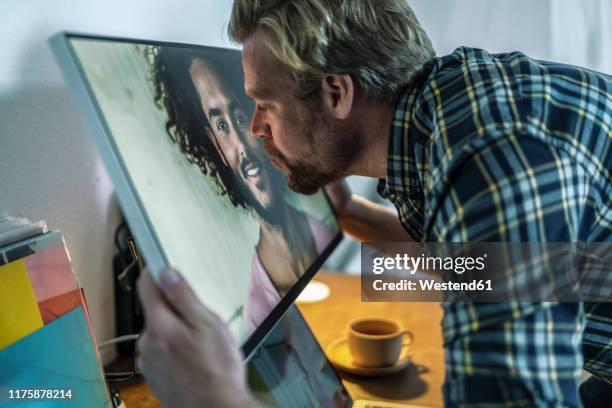 man kissing man on computer screen - zoom dating stock pictures, royalty-free photos & images