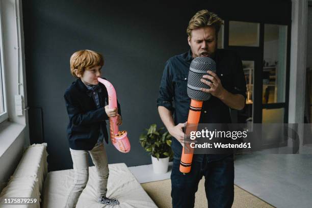 father and son playing fun instruments - blasinstrument stock-fotos und bilder