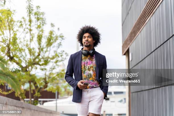 stylish man in the city on the go - multi colored jacket stock pictures, royalty-free photos & images