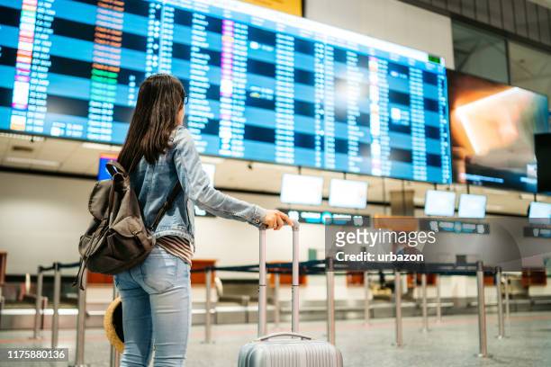 tourist checking the arrival departure board - arrival stock pictures, royalty-free photos & images