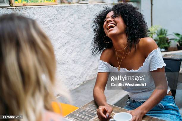 multicultural women laughing in a cafe - ironia imagens e fotografias de stock