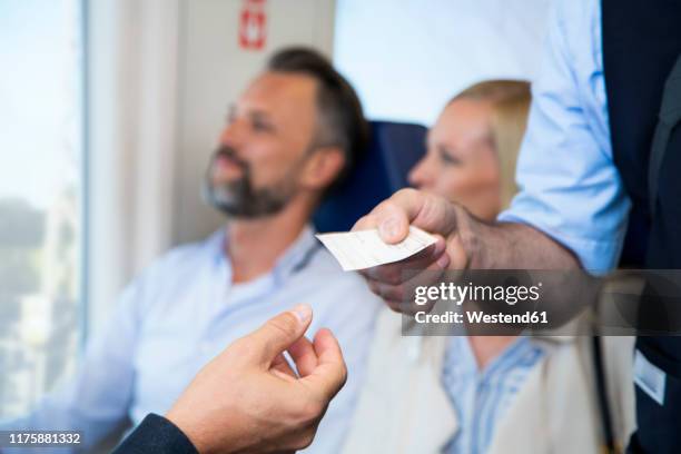 conductor checking tickets of passengers in a train - conductor stock-fotos und bilder