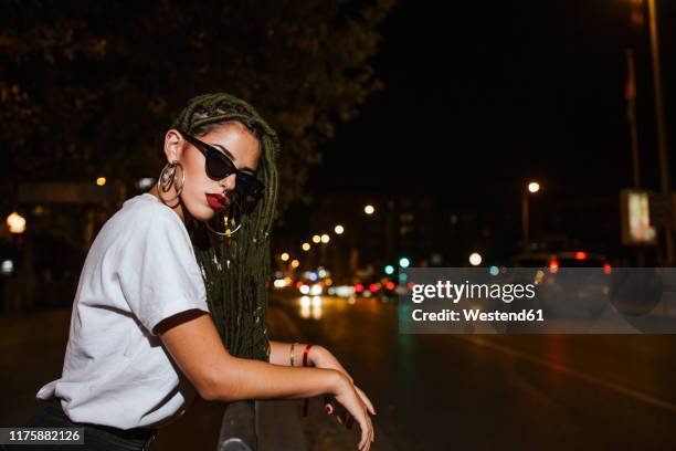 cool young woman on a steet at night in the city - pintalabios rojo fotografías e imágenes de stock