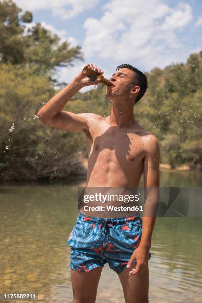 young man drinking beer at a lake, spain - beer bottle stock pictures, royalty-free photos & images