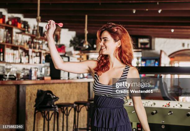 happy young woman playing darts in a sports bar - pub darts stock pictures, royalty-free photos & images