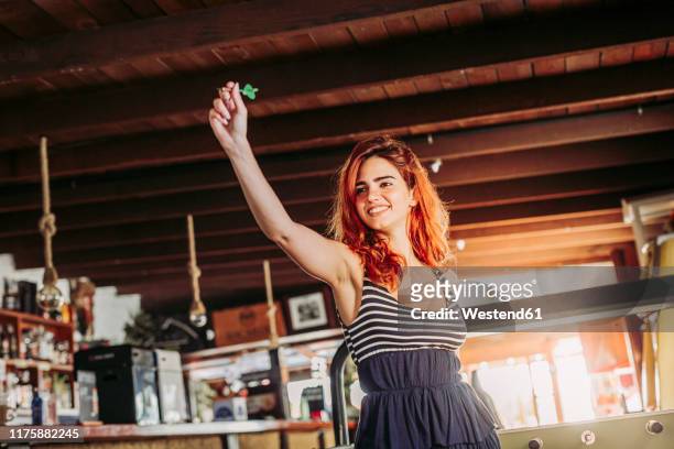 happy young woman playing darts in a sports bar - pub darts stock pictures, royalty-free photos & images