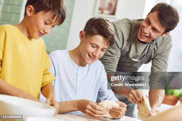 brothers preparing pizza dough in kitchen - ten to fifteen stock pictures, royalty-free photos & images