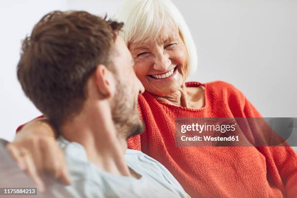 portrait of senior woman with her grown-up grandson - grandmother stock-fotos und bilder