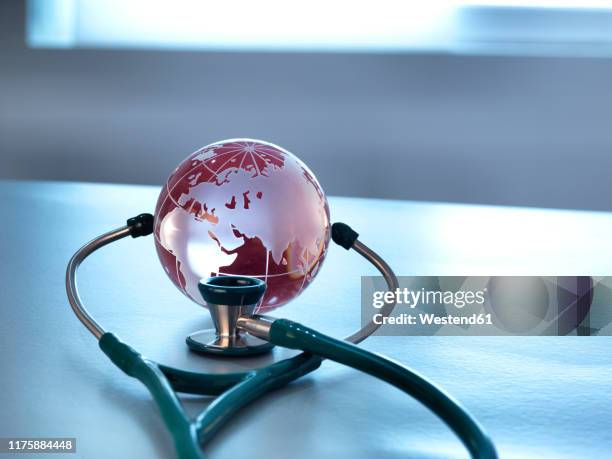 global healthcare, a glass globe and a stethoscope - who 個照片及圖片檔