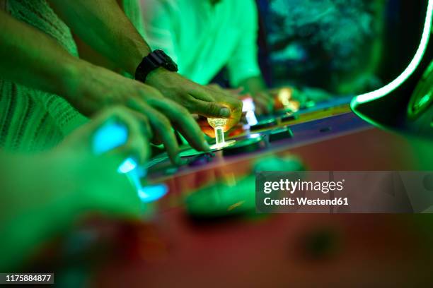 close-up of friends playing in an amusement arcade - amusement arcade stock-fotos und bilder