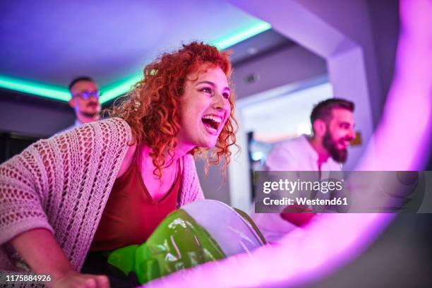 woman playing and having fun with a driving simulator in an amusement arcade - arcade stock pictures, royalty-free photos & images
