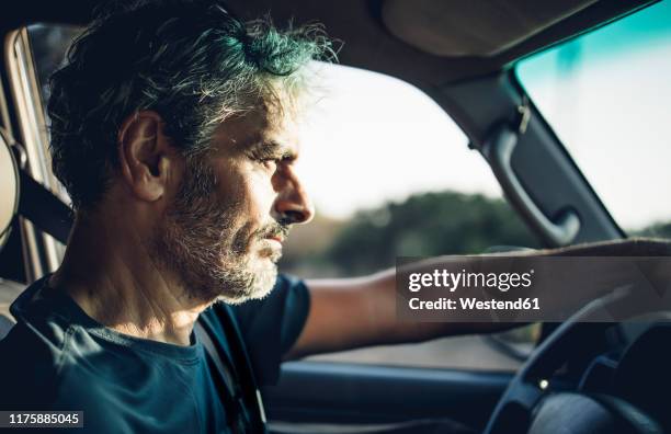 mature man driving at sunset - car interior side stock pictures, royalty-free photos & images