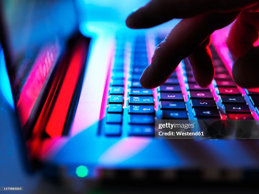 Man typing at his laptop computer at night