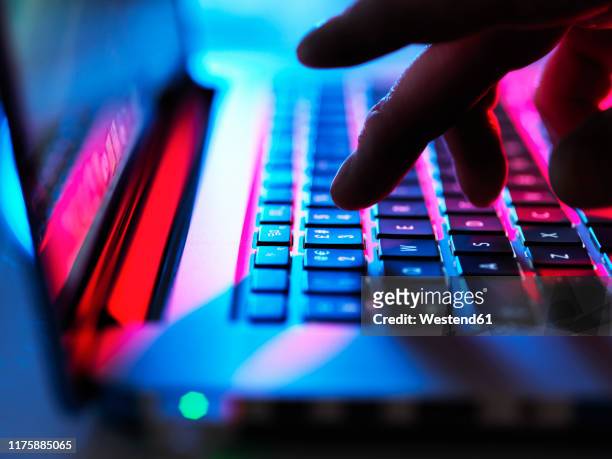 man typing at his laptop computer at night - computer hacker stockfoto's en -beelden