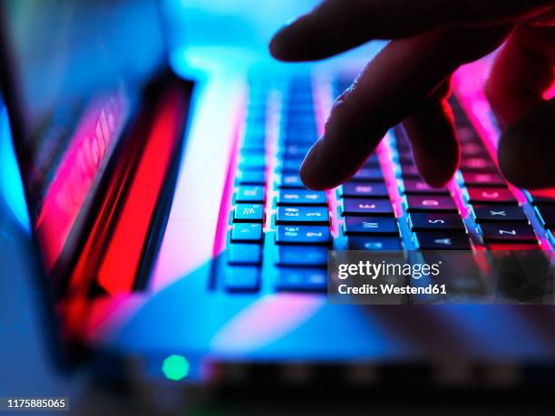 man typing at his laptop computer at night - internet obscura imagens e fotografias de stock