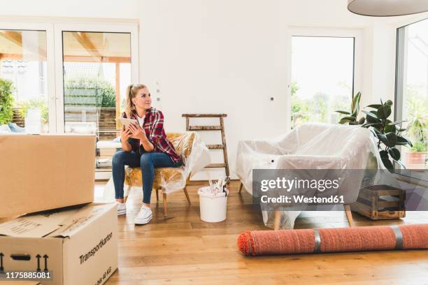 woman moving into new home using tablet - step stool stock pictures, royalty-free photos & images