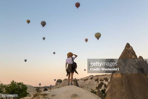 young woman and hot air ballons, goreme, cappadocia, turkey - air travel bildbanksfoton och bilder