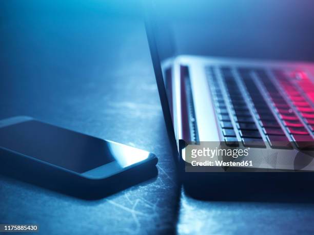 laptop and smartphone at night - dark web stock pictures, royalty-free photos & images