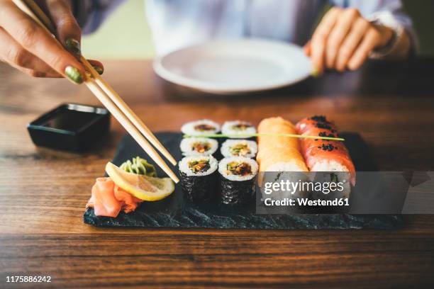 close-up of a woman eating sushi in a restaurant - sushi restaurant 個照片及圖片檔