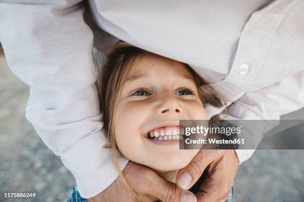 portrait of happy girl embraced by her father - unschuld stock-fotos und bilder
