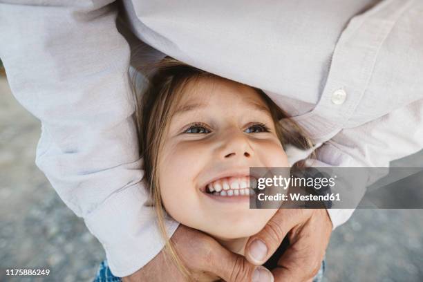 portrait of happy girl embraced by her father - tooth bonding stock pictures, royalty-free photos & images