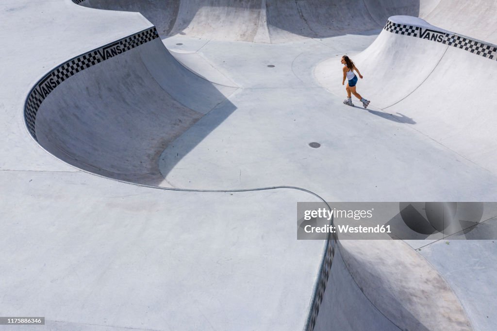 Young woman inline skating in skatepark