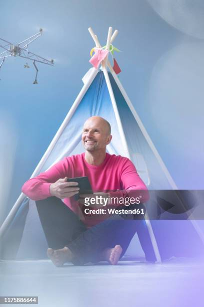 smiling man flying drone in children's room - tipi stock pictures, royalty-free photos & images