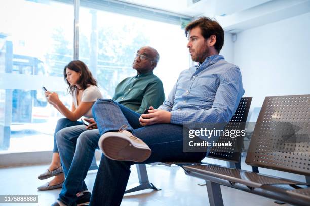 multi-ethnic patients sitting at waiting room - waiting room stock pictures, royalty-free photos & images
