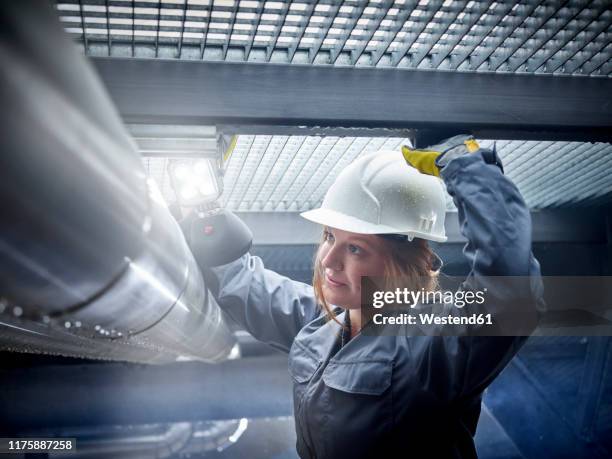 craftswoman wearing hard hat working at pipe - pipe women stock pictures, royalty-free photos & images