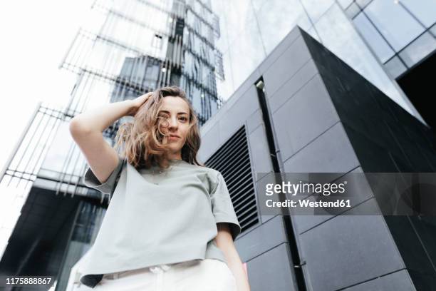 portrait of smiling woman looking at camera, modern office buildings in the background, low angle view - view from below fotografías e imágenes de stock