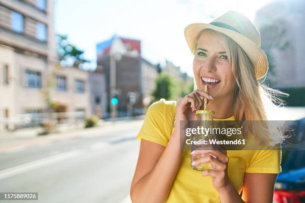 happy young woman enjoying a drink in the city - drinking water outside stock pictures, royalty-free photos & images