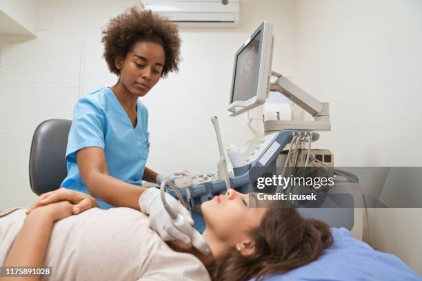 young female nurse examining patient's throat - diagnostic medical tool stock pictures, royalty-free photos & images