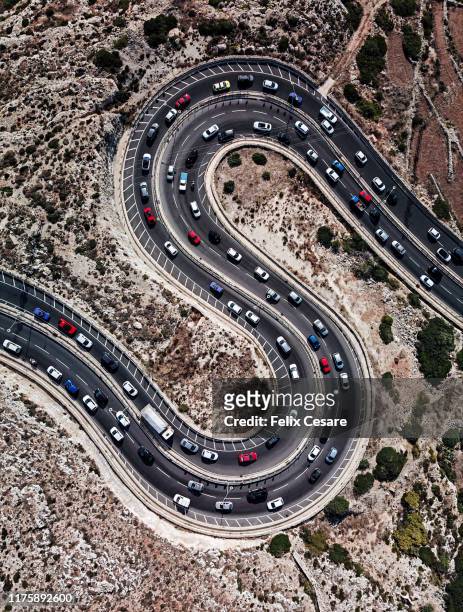 aerial view of cars on winding road shaped as letter s - car fumes stock-fotos und bilder