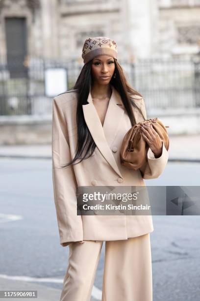 Designer and digital Influencer Rachel Michelle wears a Louis Vuitton scarf and an R.Michel'le the label suit and bag during London Fashion Week...