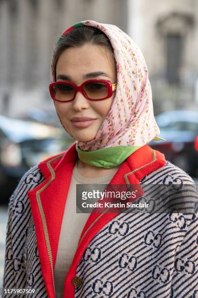 Guest wears a Gucci jacket and headscarf, Red sunglasses and a Ralph Lauren knit top during London Fashion Week September 2019 on September 13, 2019...